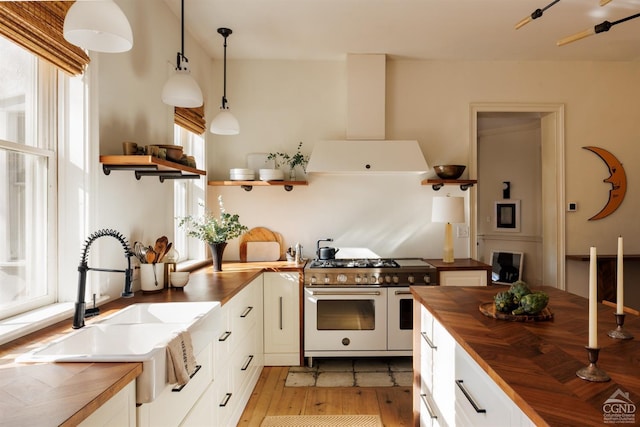 kitchen with plenty of natural light, extractor fan, range with two ovens, and wood counters