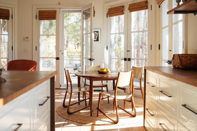 dining area with light tile patterned flooring and french doors