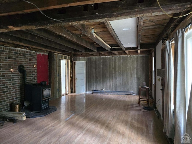 basement featuring wood-type flooring and a wood stove