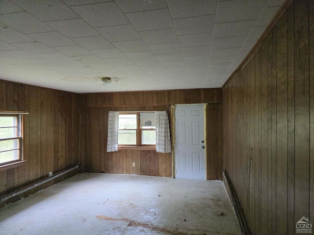 empty room with a wealth of natural light and wooden walls