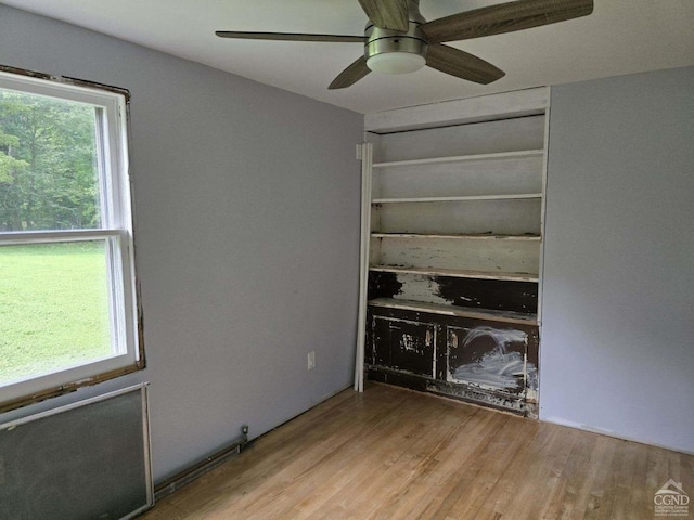 unfurnished living room with ceiling fan, a healthy amount of sunlight, and light wood-type flooring