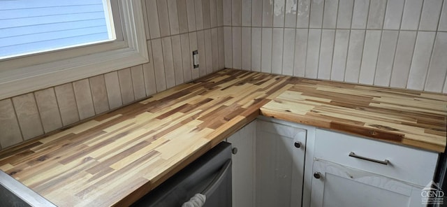 room details featuring dishwashing machine and wood walls