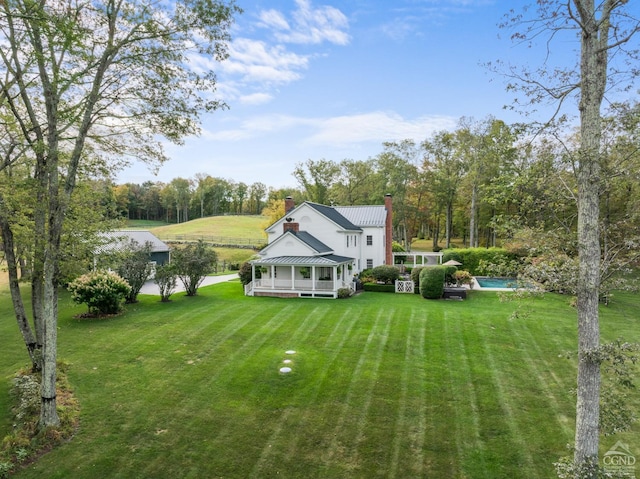 rear view of property with a sunroom and a lawn