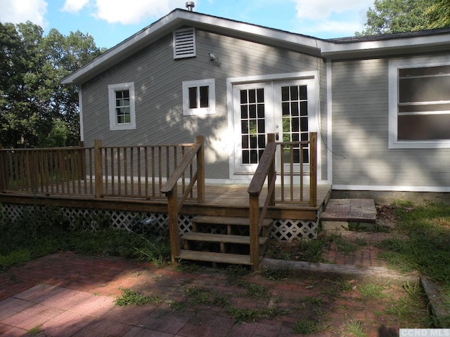 rear view of house with a wooden deck and french doors