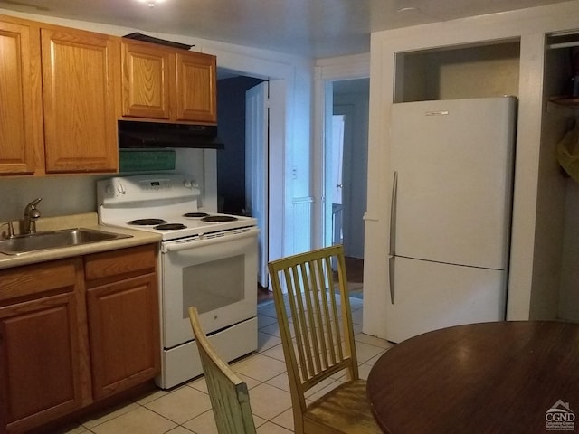 kitchen with light tile patterned flooring, white appliances, and sink