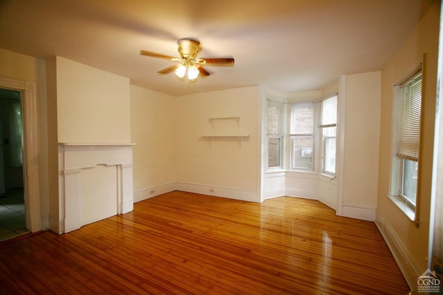 unfurnished living room with wood-type flooring and ceiling fan