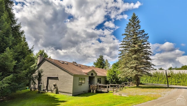 back of property with a wooden deck and a yard