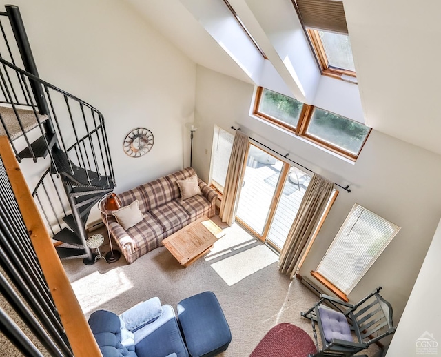 carpeted living room featuring a towering ceiling