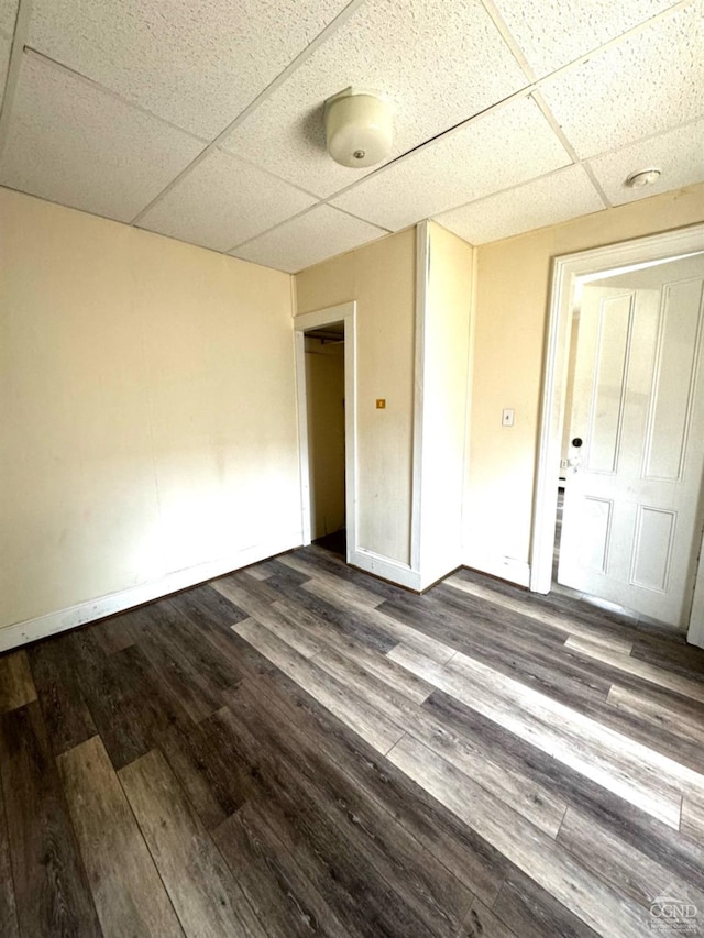 empty room with hardwood / wood-style flooring and a paneled ceiling