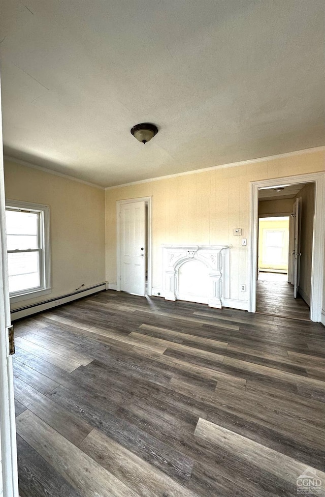 spare room with dark hardwood / wood-style floors and a baseboard heating unit