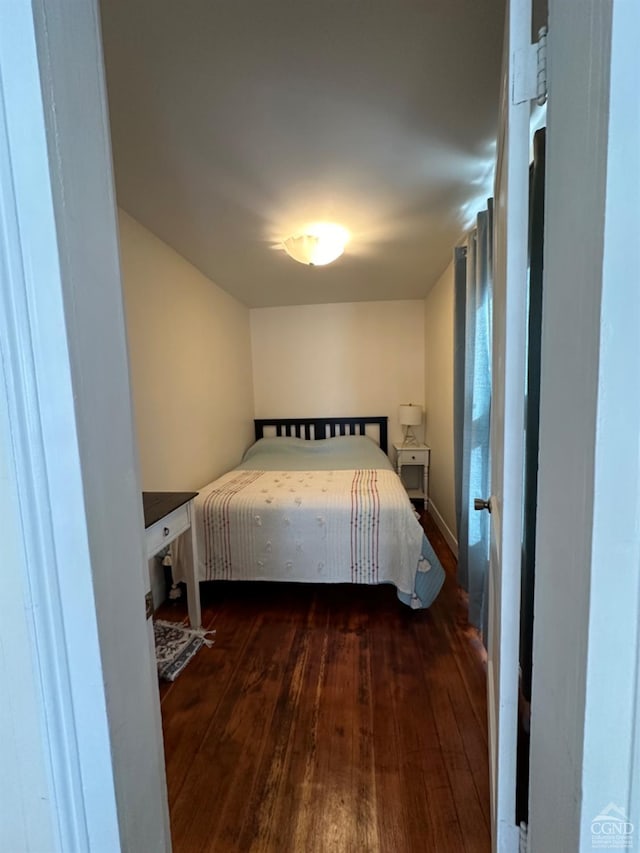 bedroom with dark wood-type flooring