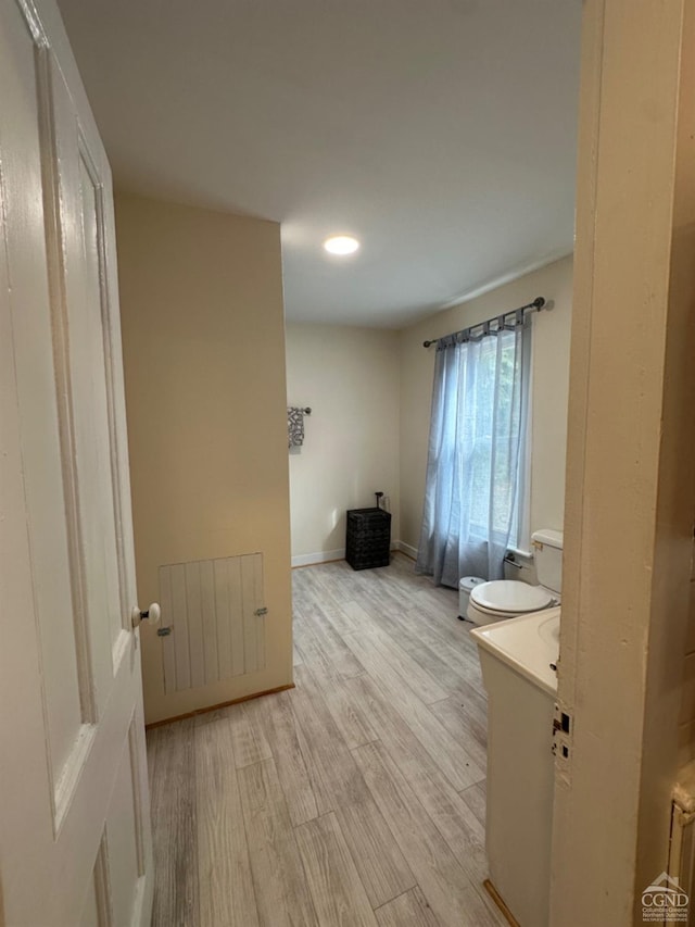 bathroom with toilet, radiator heating unit, vanity, and hardwood / wood-style flooring