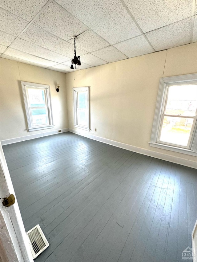 spare room featuring hardwood / wood-style floors, a paneled ceiling, and ceiling fan