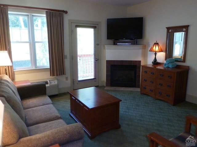 living room with dark carpet, an AC wall unit, and a tile fireplace