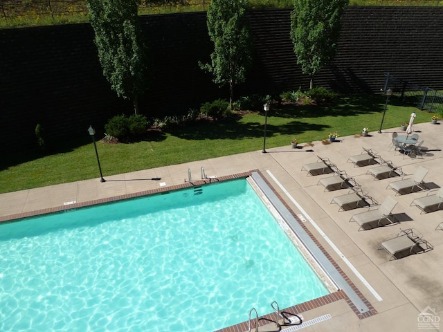 view of swimming pool featuring a lawn and a patio area