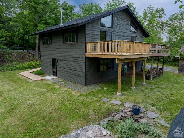 back of property featuring a lawn and a wooden deck