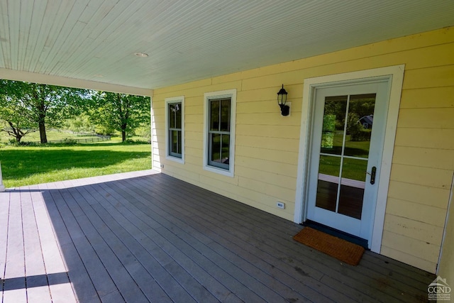 wooden terrace featuring a lawn