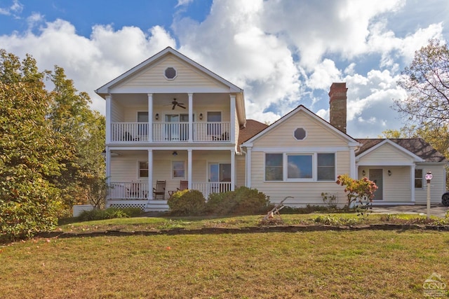 view of front of property featuring a balcony, a front lawn, and covered porch