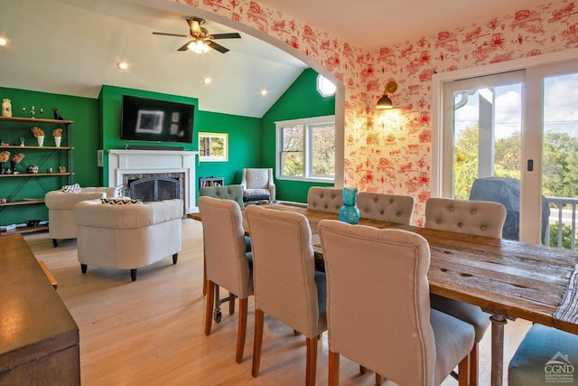 dining space with ceiling fan, vaulted ceiling, and light hardwood / wood-style flooring