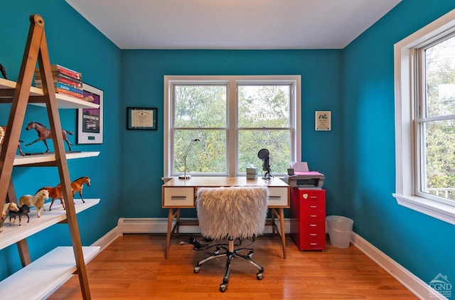 home office featuring hardwood / wood-style floors and a baseboard heating unit