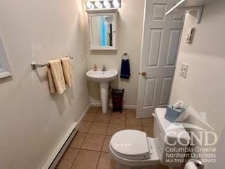 bathroom with tile patterned floors, baseboard heating, sink, and toilet