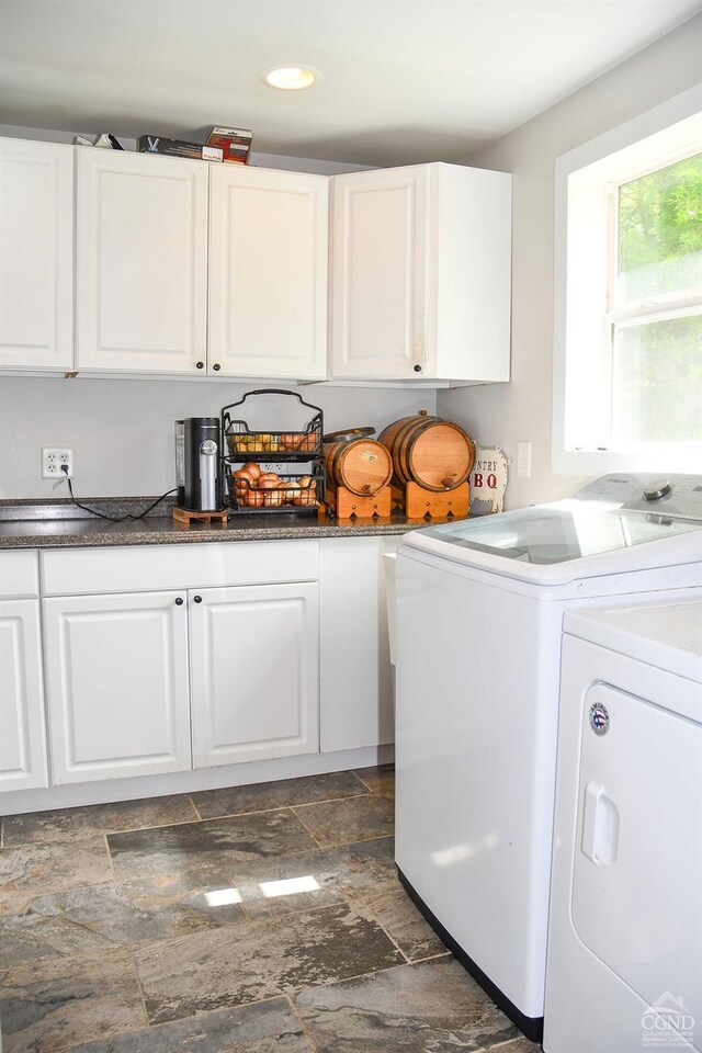 washroom with cabinets and washer and dryer