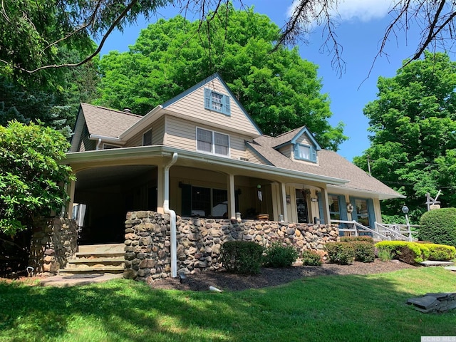 view of front of house featuring covered porch and a front lawn