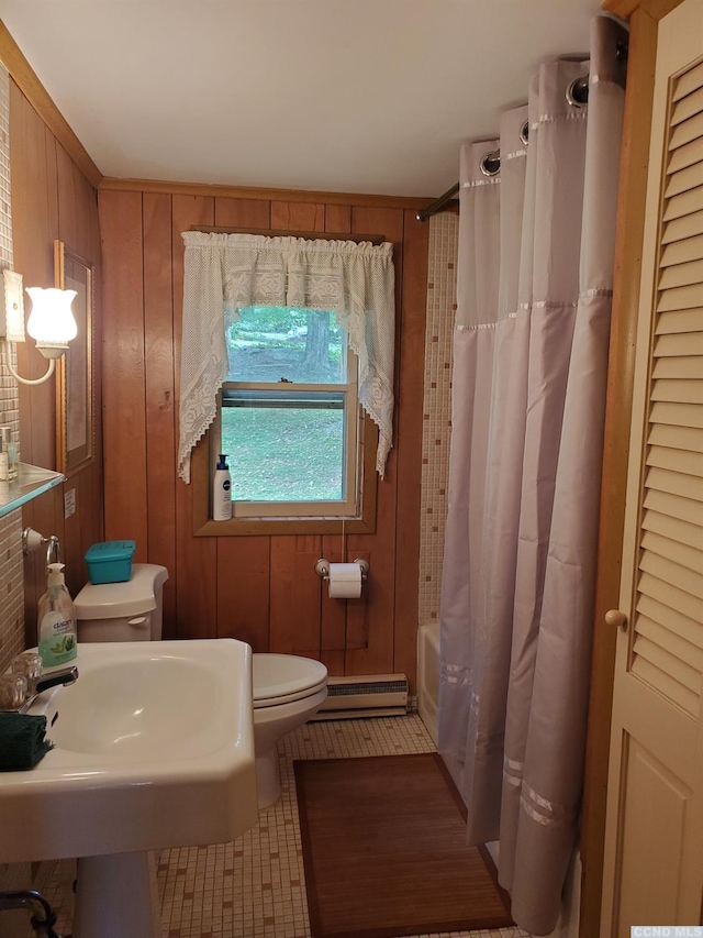 full bathroom featuring baseboard heating, wooden walls, and tile patterned flooring