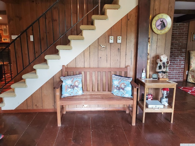 stairway featuring hardwood / wood-style flooring and wooden walls