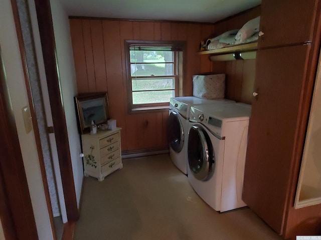 laundry area featuring washing machine and clothes dryer and wooden walls