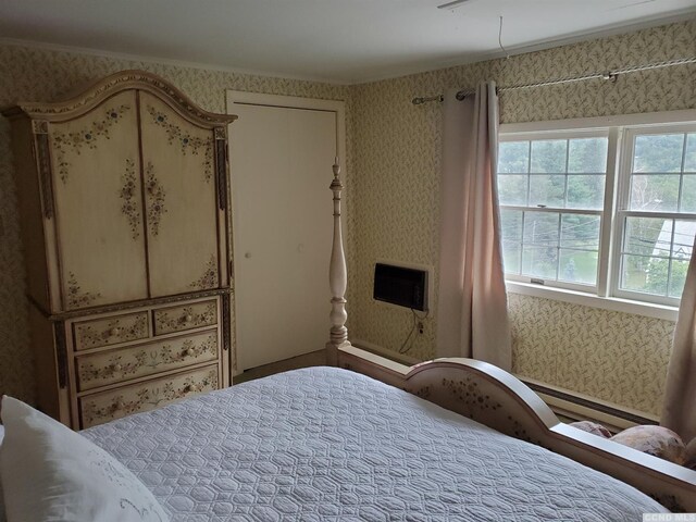 bedroom featuring baseboard heating and ornamental molding