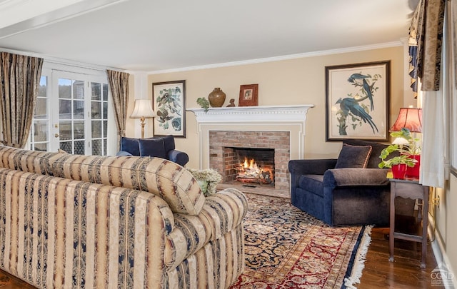 living area with a fireplace, crown molding, and wood finished floors