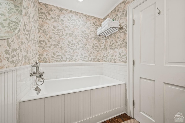 full bath with wallpapered walls, a garden tub, and wainscoting
