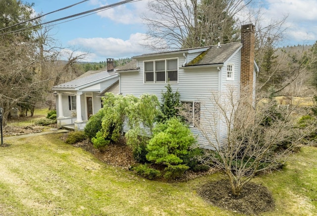 view of home's exterior featuring a lawn and a chimney