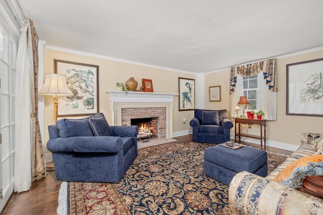living area with baseboards, crown molding, wood finished floors, and a brick fireplace