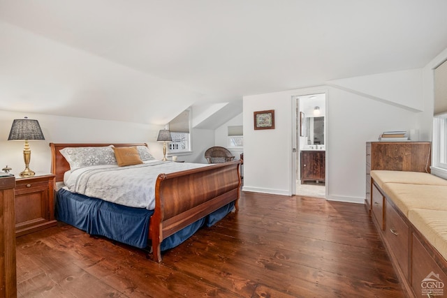 bedroom featuring connected bathroom, dark wood-style floors, lofted ceiling, and baseboards