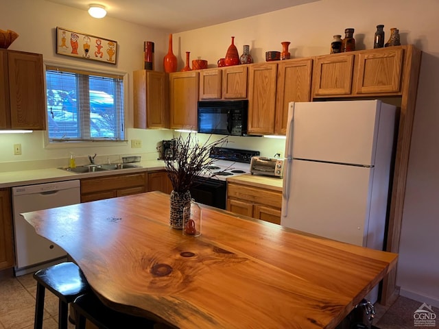 kitchen featuring brown cabinets, a breakfast bar area, butcher block counters, a sink, and white appliances