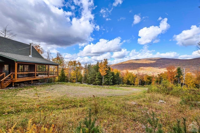 view of yard with a deck with mountain view