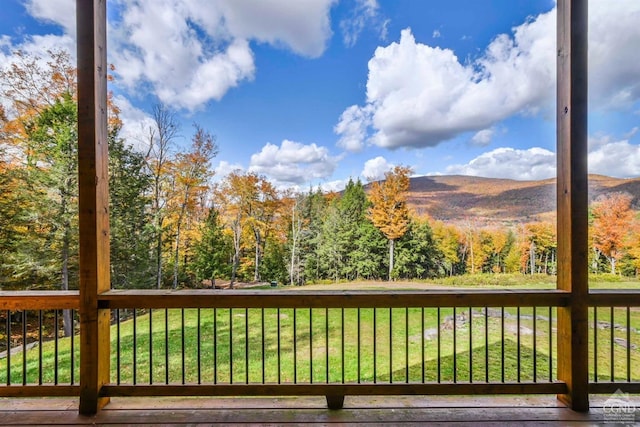 wooden terrace featuring a mountain view and a yard