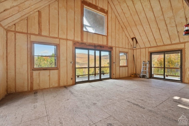 unfurnished living room featuring a mountain view, high vaulted ceiling, and a wealth of natural light