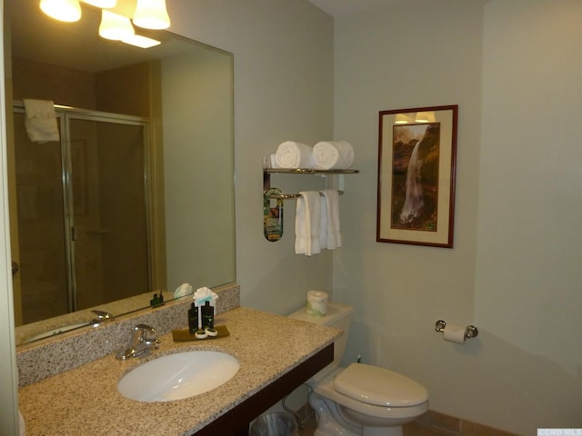 bathroom featuring toilet, an enclosed shower, and sink