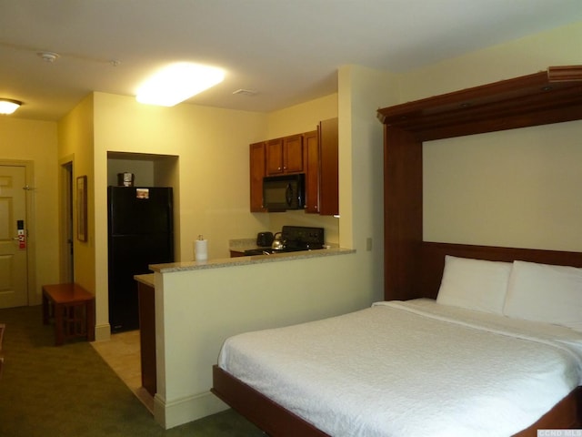 bedroom featuring black refrigerator and carpet flooring