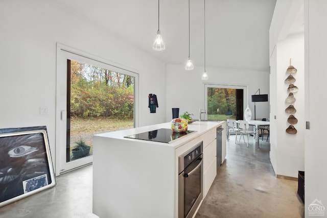 kitchen featuring a center island with sink, decorative light fixtures, white cabinets, and appliances with stainless steel finishes