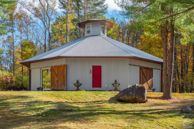 view of outbuilding featuring a lawn