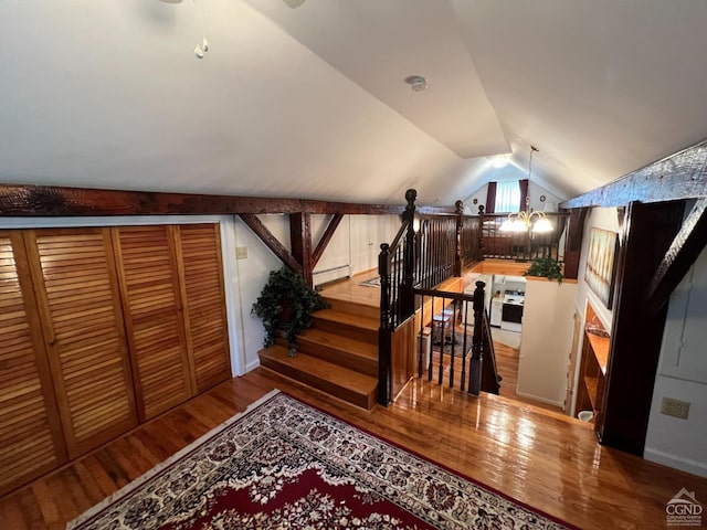 stairway with lofted ceiling and hardwood / wood-style flooring