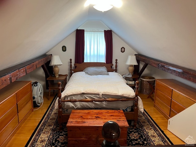 bedroom with vaulted ceiling and light wood-type flooring