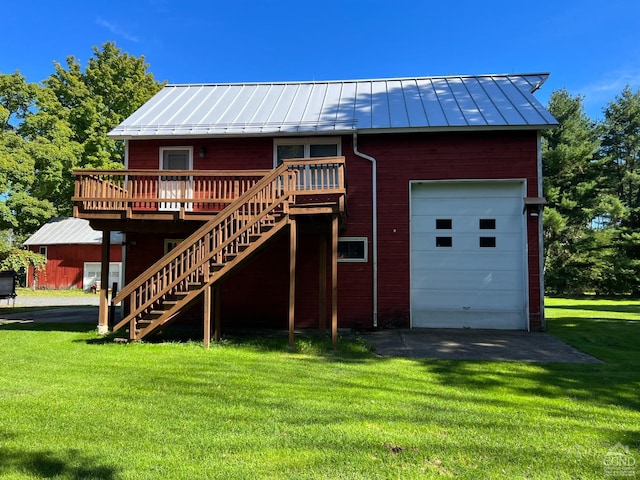 back of house featuring a garage, a yard, and a wooden deck