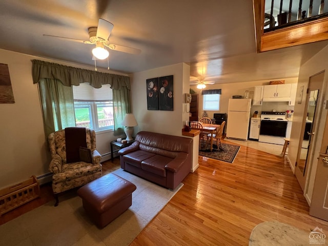 living room with ceiling fan, plenty of natural light, a baseboard radiator, and light wood-type flooring