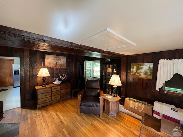 sitting room featuring wood walls and light hardwood / wood-style floors