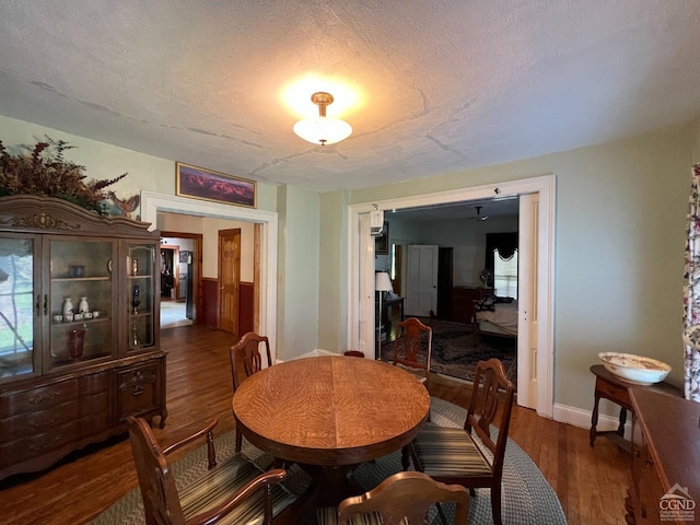 dining space with dark hardwood / wood-style flooring and a textured ceiling